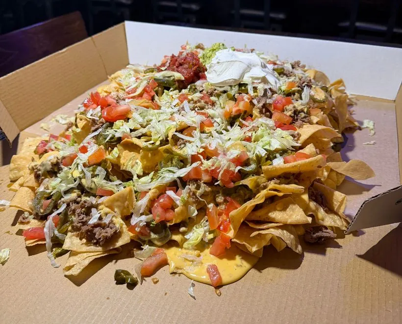 Nacho Bar — loaded nachos with beef, queso, jalapenos, lettuce, tomatoes, salsa, guac and sour cream